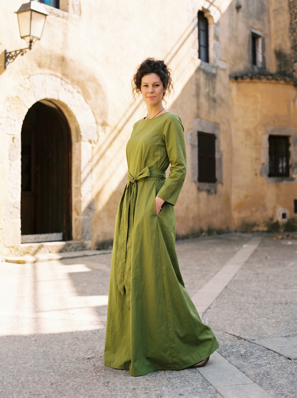 Olive green linen long-sleeve maxi dress with bow belt on Mediterranean saffron village plaza — Souls In Clothes